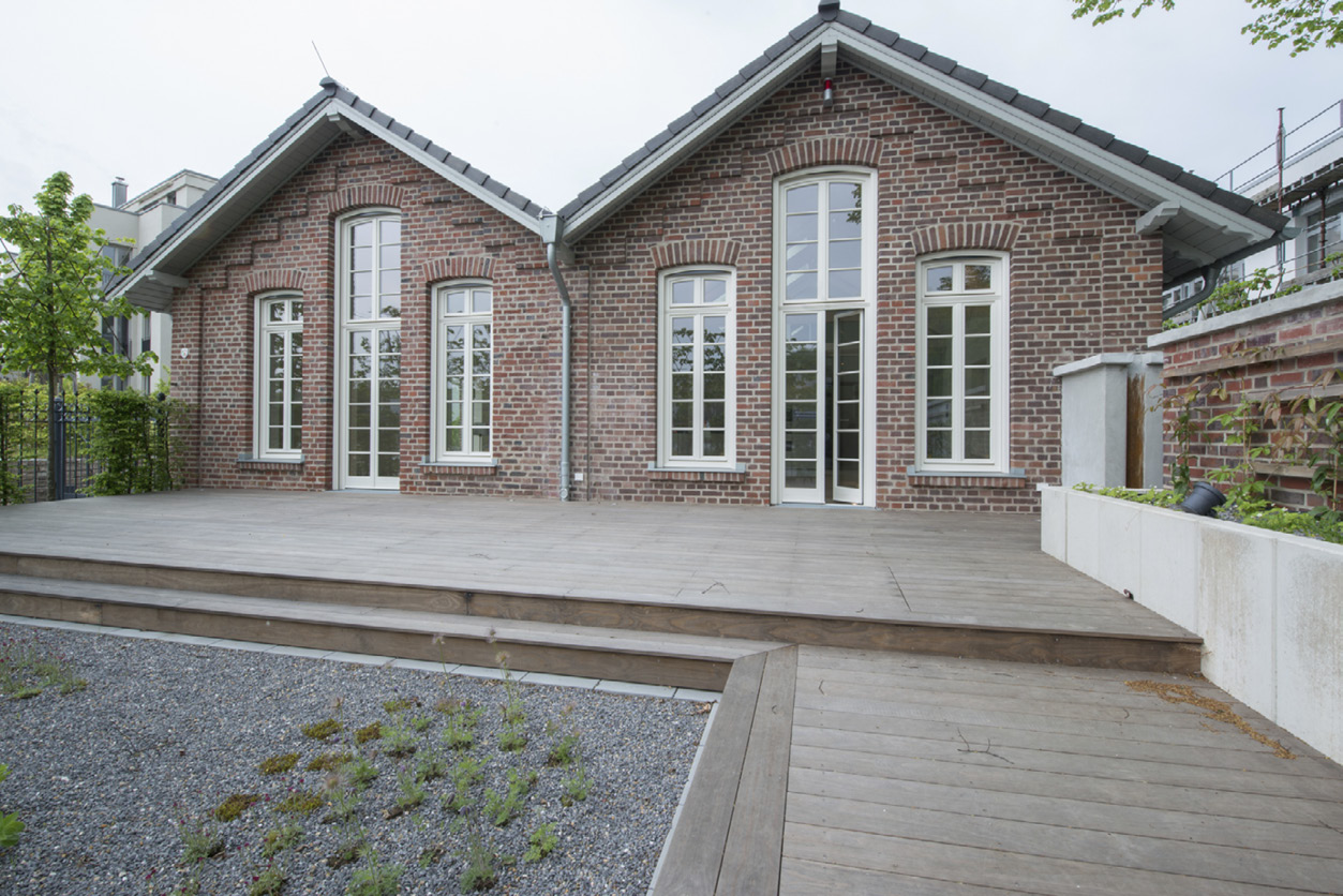Seeseite des Bootshauses: zwei Backsteingiebel mit Sprossenfenstern und Holzterrasse