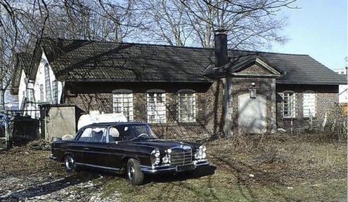 Das Bootshaus vor der Sanierung, mit altem Mercedes vor der Tür